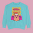 A holiday sweatshirt featuring a cute ghost character wearing a Santa hat, with two smaller ghosts on either side. Above them is the playful text "Boo Humbug," surrounded by snowflakes and festive elements. The design humorously combines spooky and festive themes for a unique holiday look.